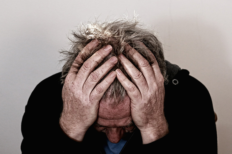 Image of depressed man holding his head in his hands