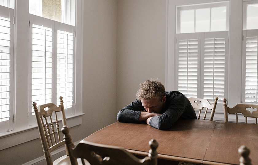 Picture of a man at a table dealing with social anxiety