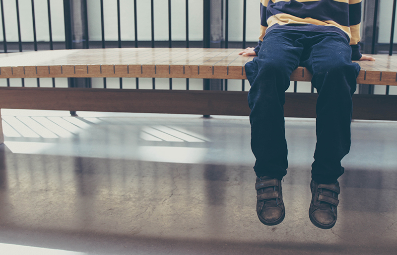 Picture of a neglected child sitting on a bench
